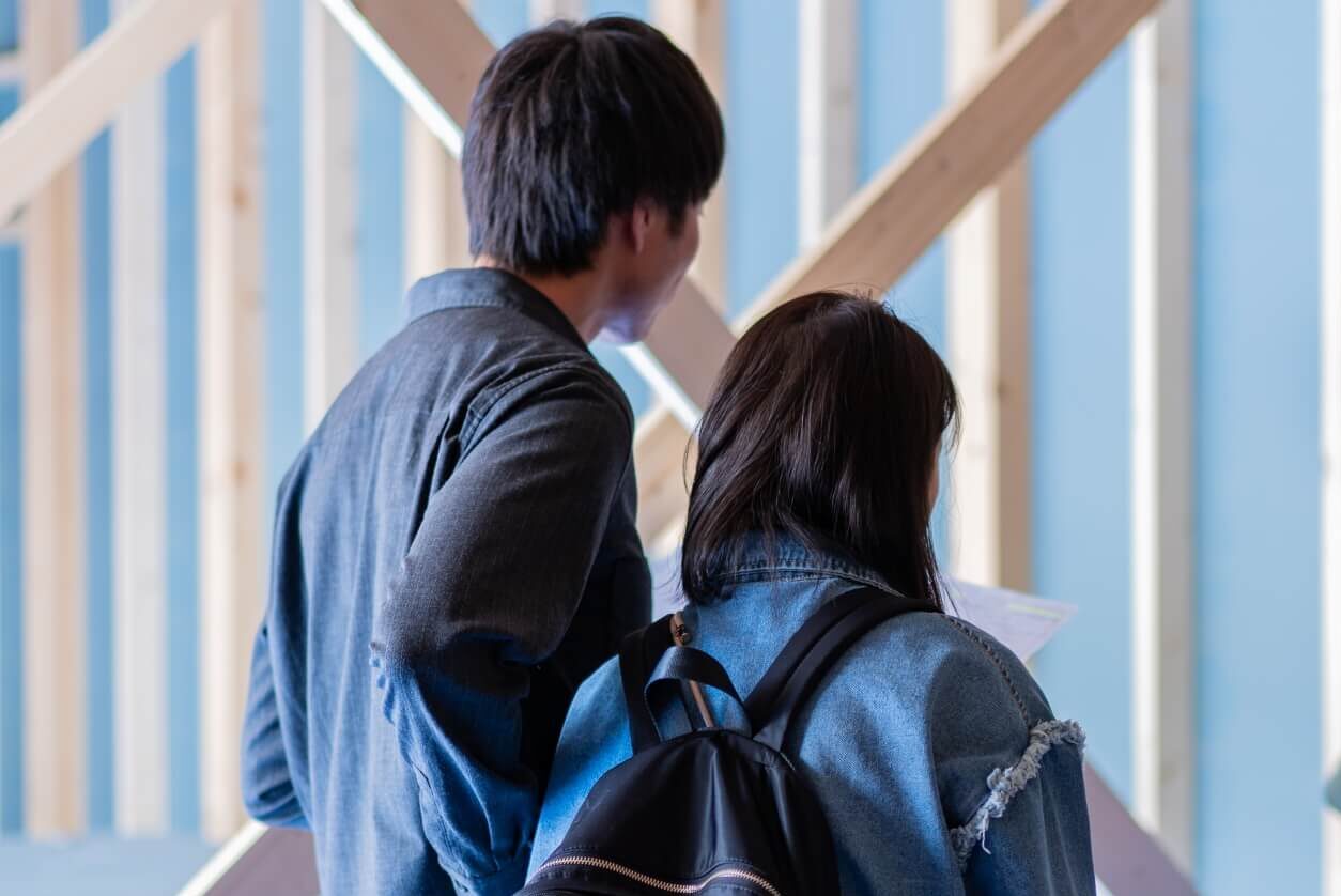 山梨県の建築現場で、お施主さまご家族と現場監督が現場打合せをしている様子。