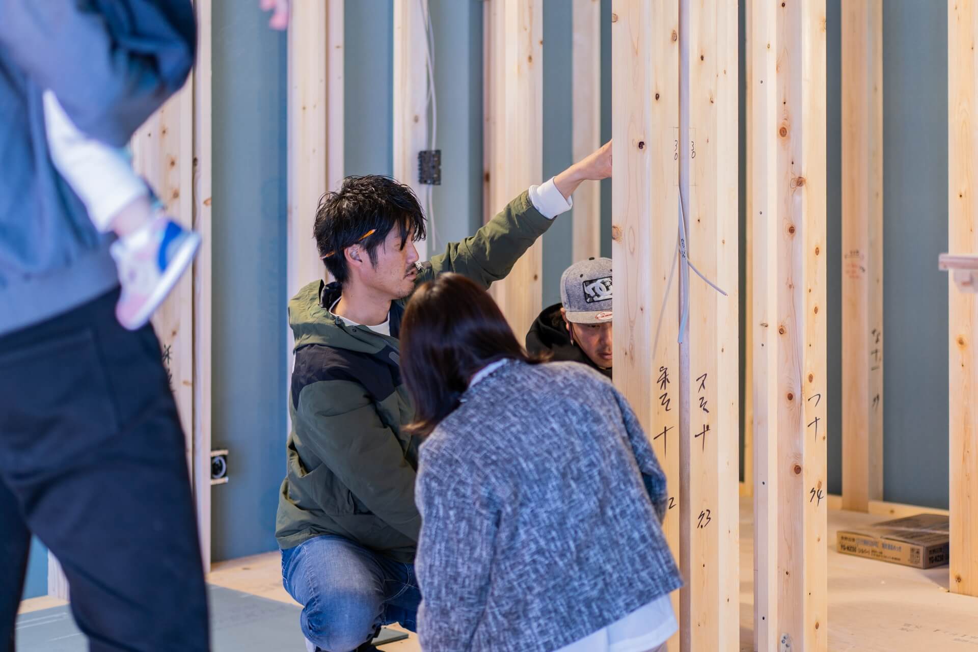山梨県の建築現場で、スタッフとオーナー様がスイッチやコンセント位置を打合せしている様子。