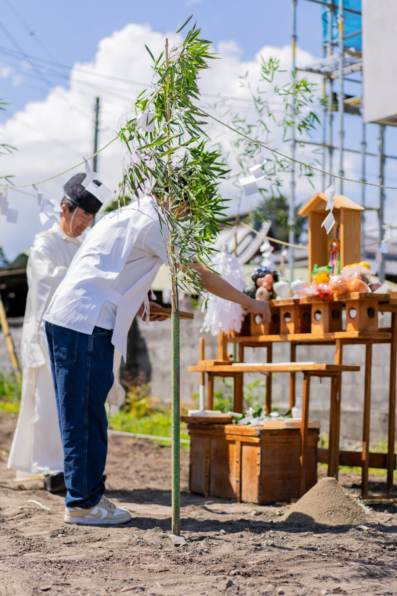 山梨県での新築工事に先立ち、地鎮祭にて祭壇にお供えをするお施主様の様子