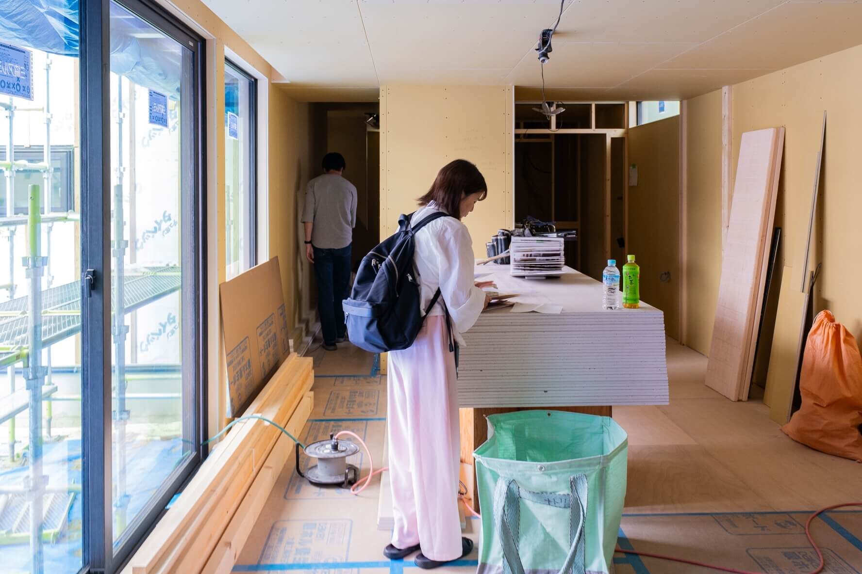 山梨県の建築現場で、オーナー様が設計資料を確認しながら打ち合わせをしている様子。