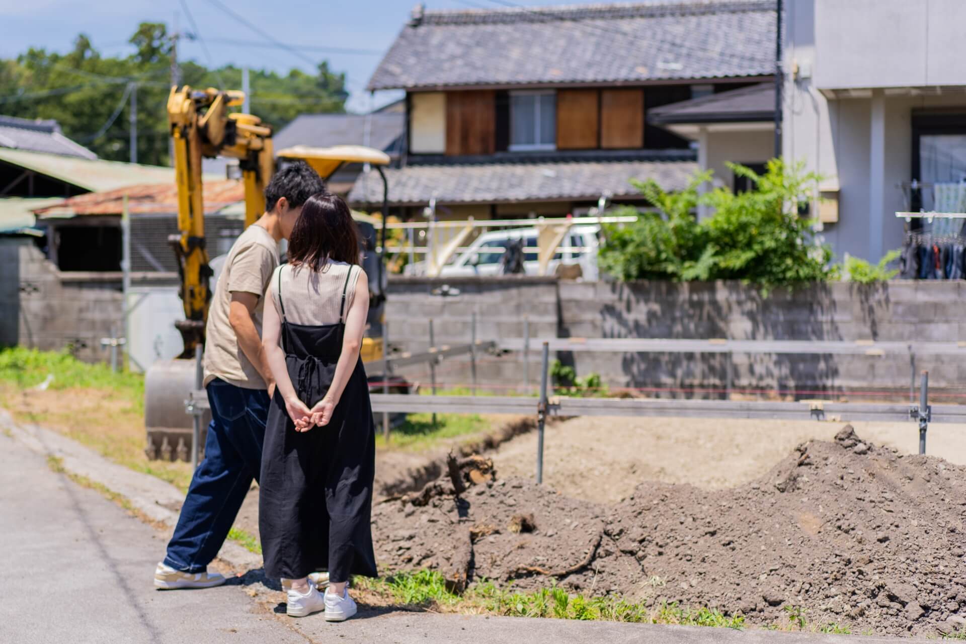 山梨県南アルプス市寺部で、新築住宅の建設予定地を眺めるお施主様ご夫婦の後ろ姿。着工前の敷地を見つめる印象的なシーン。