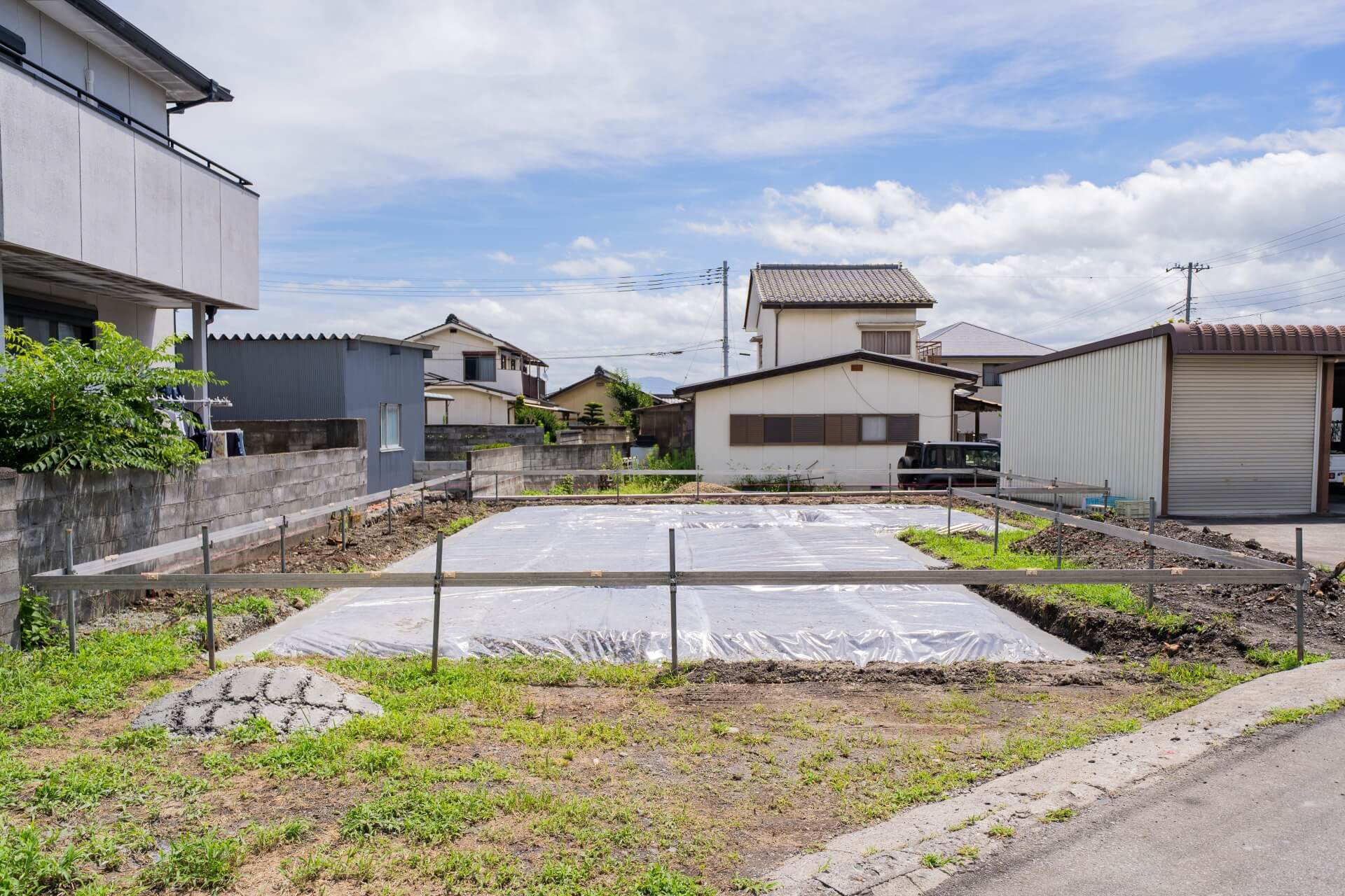 山梨県南アルプス市寺部で、防湿シートを施工したばかりの住宅建築現場。基礎工事前の整った状態が確認できる。
