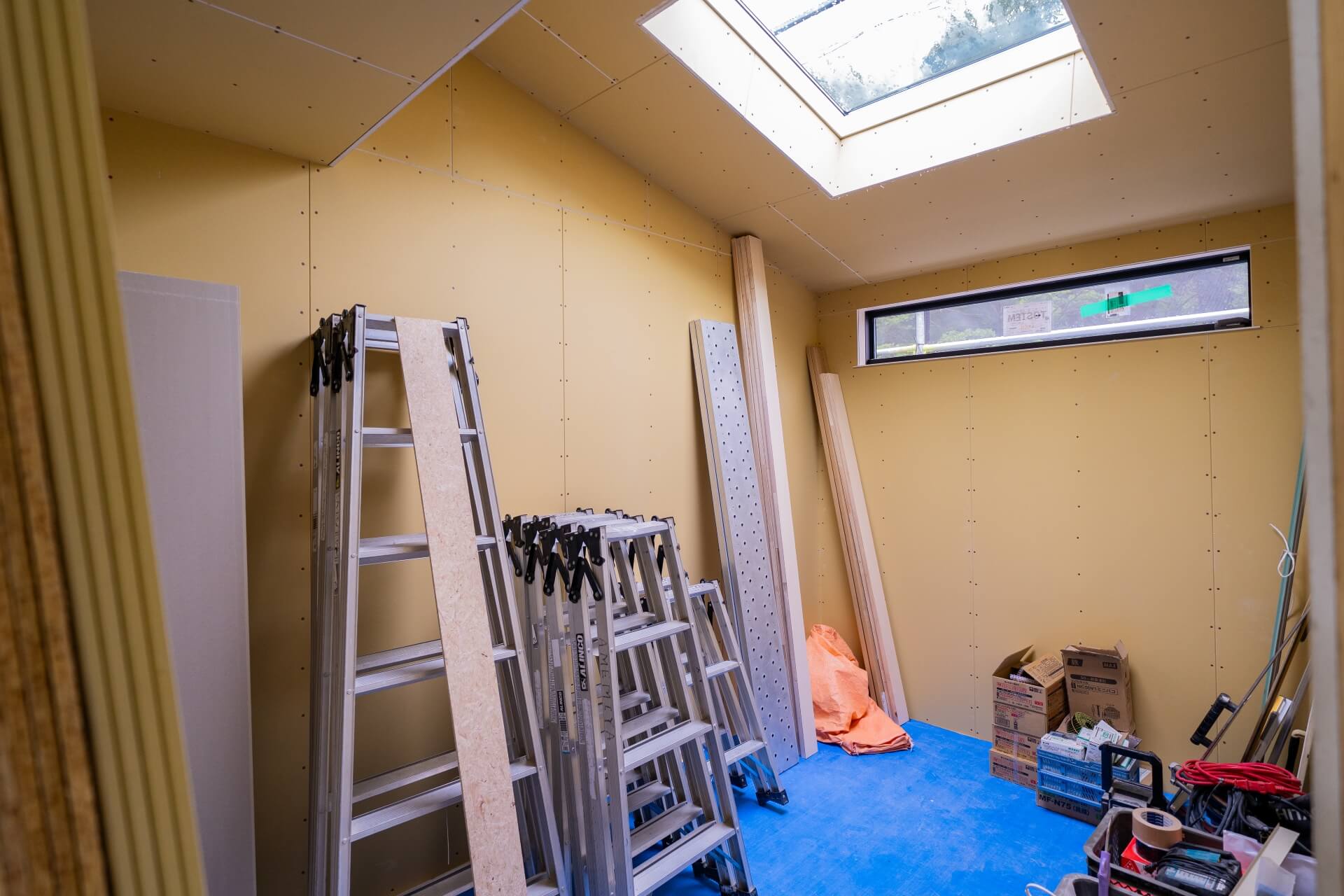 山梨県富士ケ嶺で建築中のヴィラ。天窓から光が差し込む内装工事中の部屋の様子。