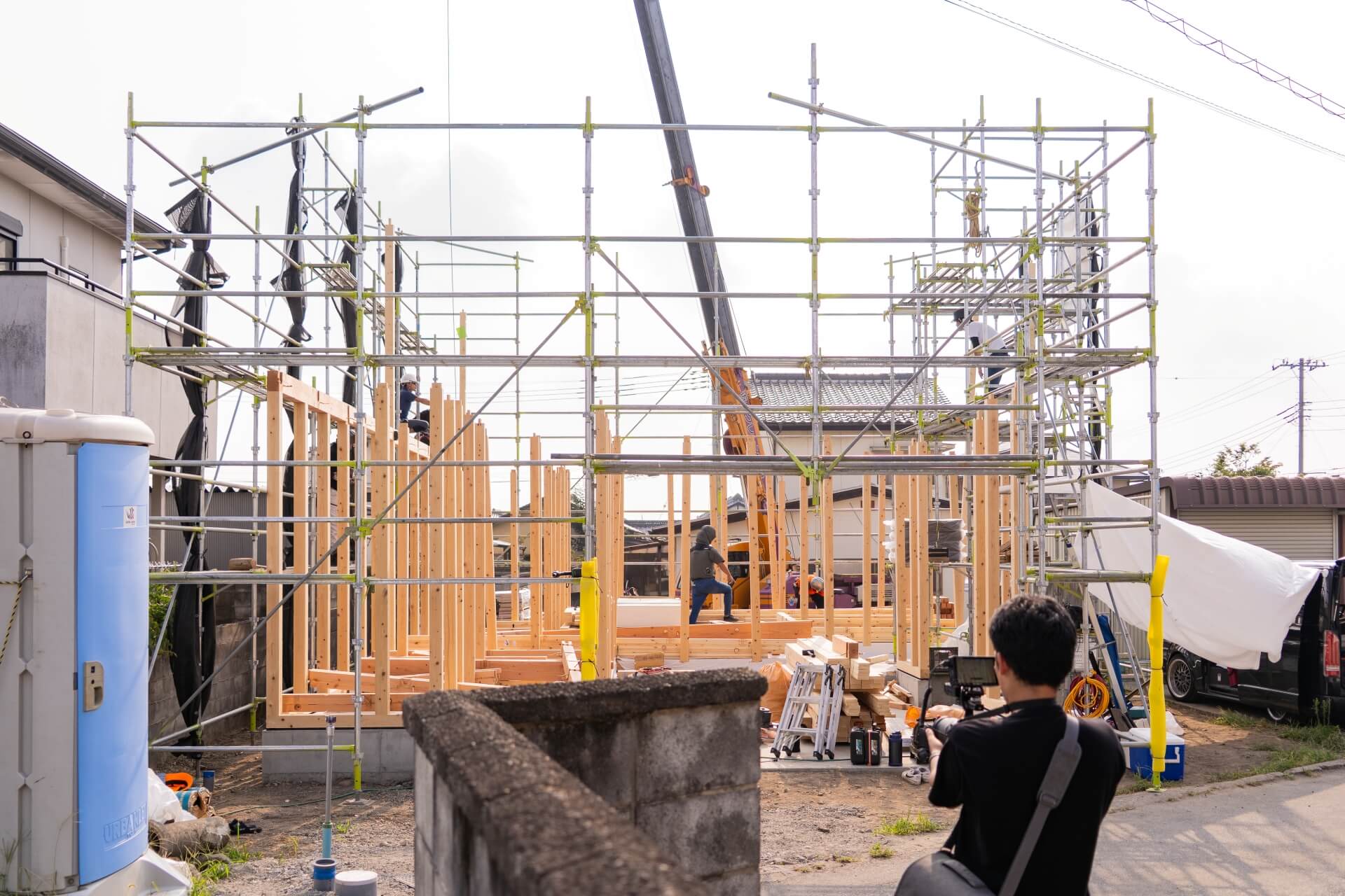 山梨県南アルプス市寺部の新築現場の建方の様子を撮影しているスタッフ。