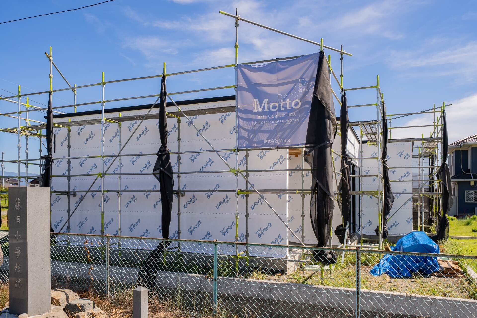 山梨県南アルプス市藤田の現場にて施工中の外観の様子。白い防水シートが貼られている。