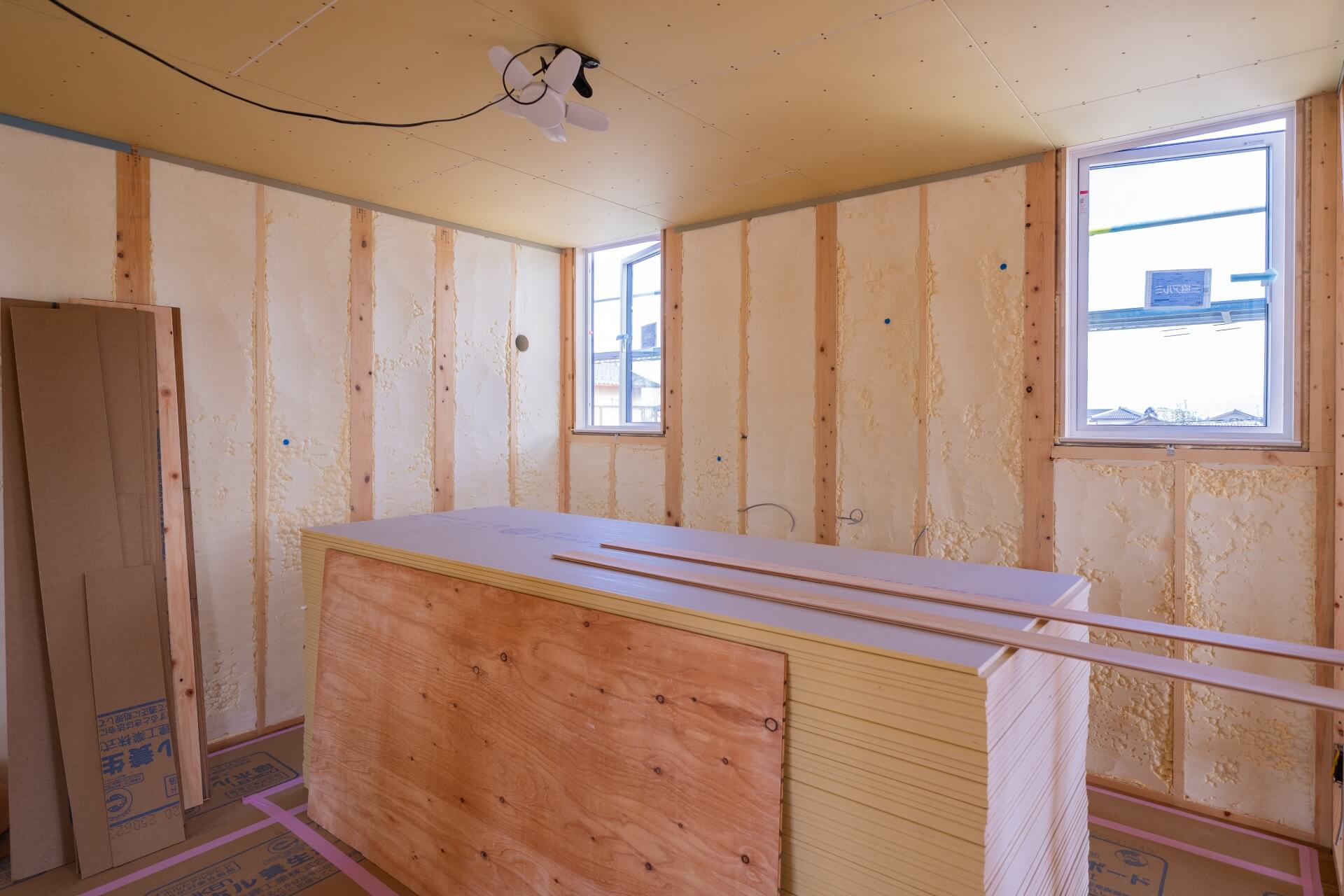 山梨県南アルプス市寺部の新築現場にて洋室に石膏ボードが積まれている様子。