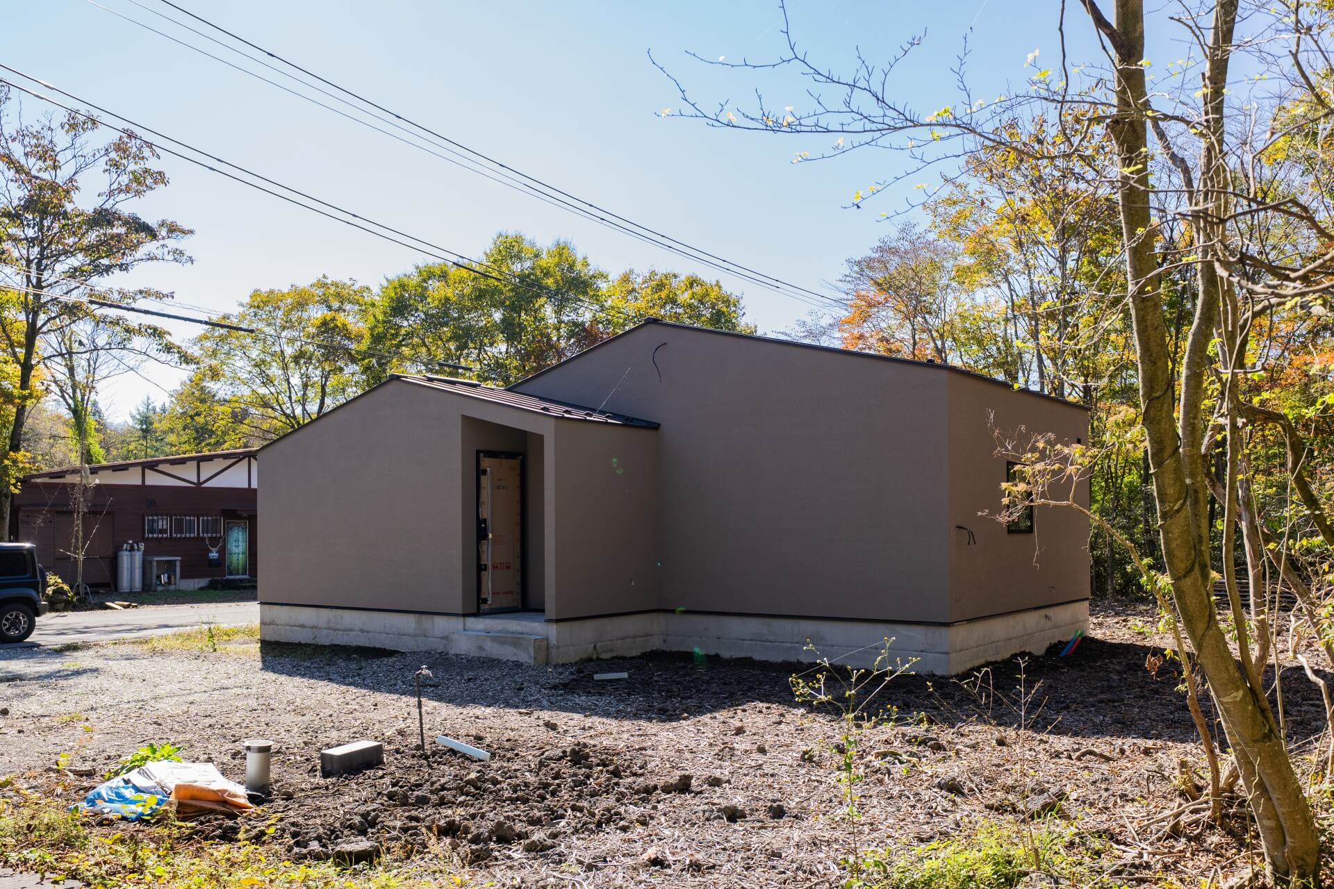 山梨県富士ケ嶺で建築中のヴィラの外観の様子。森の中に建物が建っている。