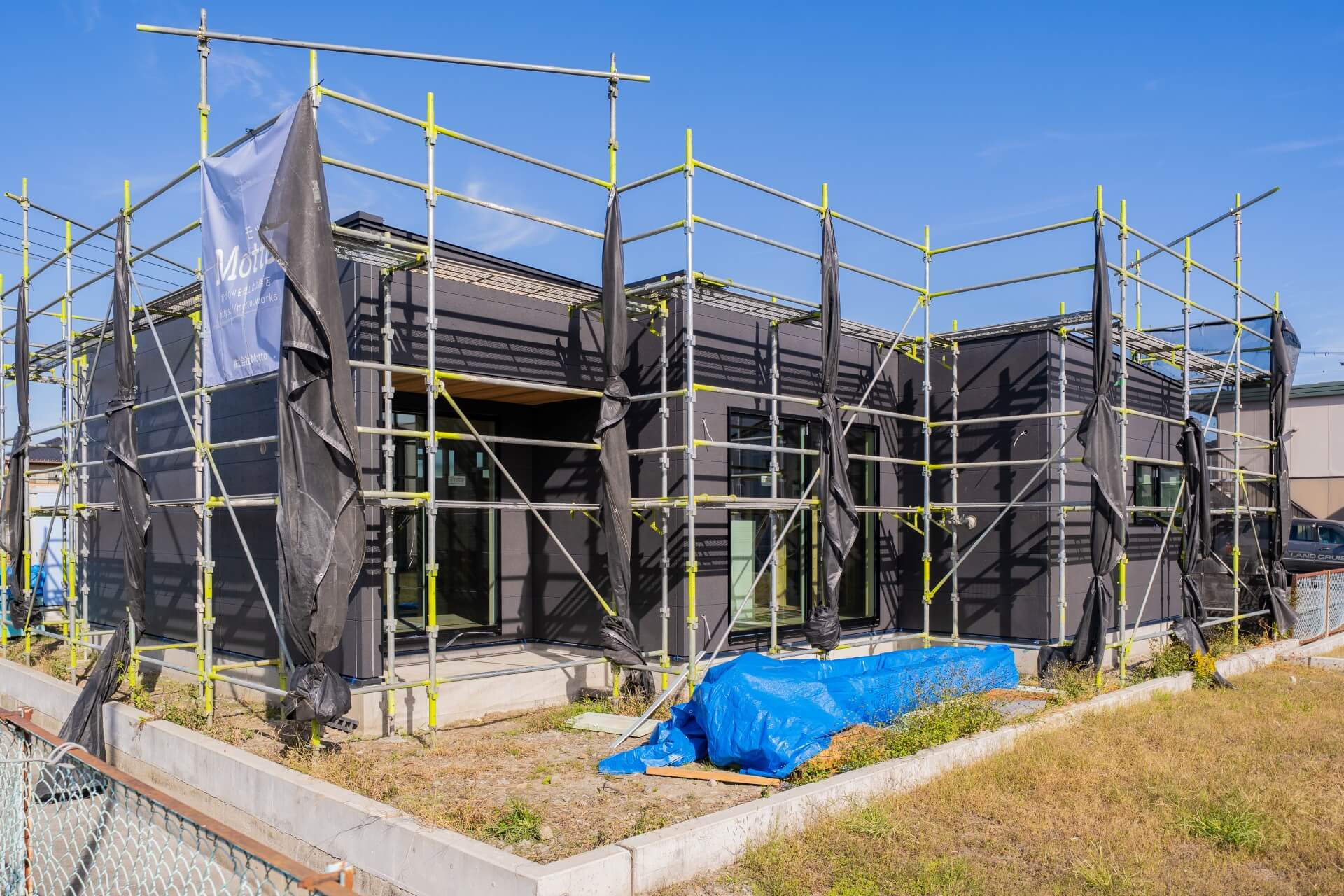 山梨県南アルプス市藤田の現場にて施工中の外観の様子。足場に囲まれている。