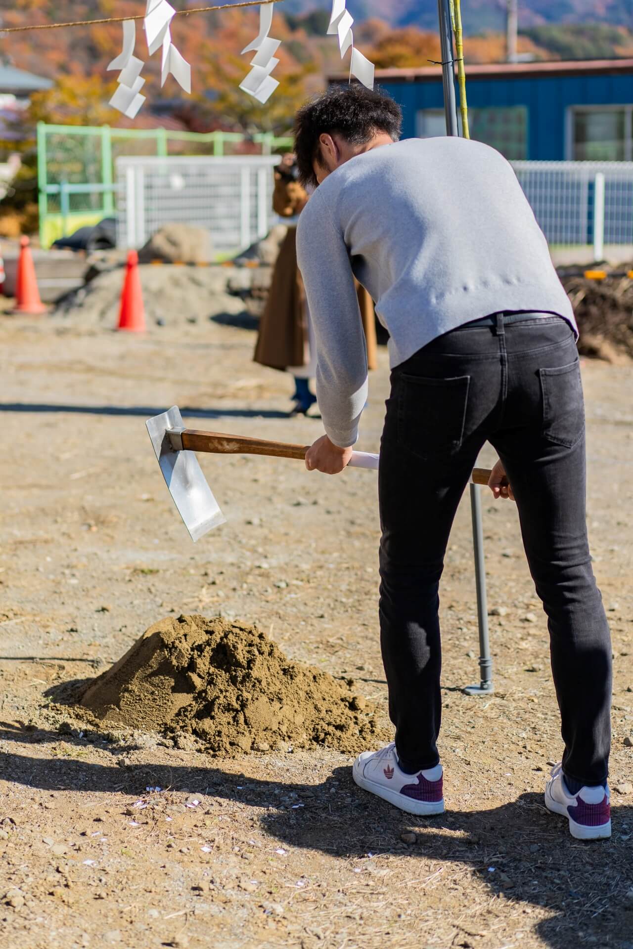 山梨県富士吉田市大明見の建築現場。地鎮祭にて旦那様が鍬入れをしている様子。