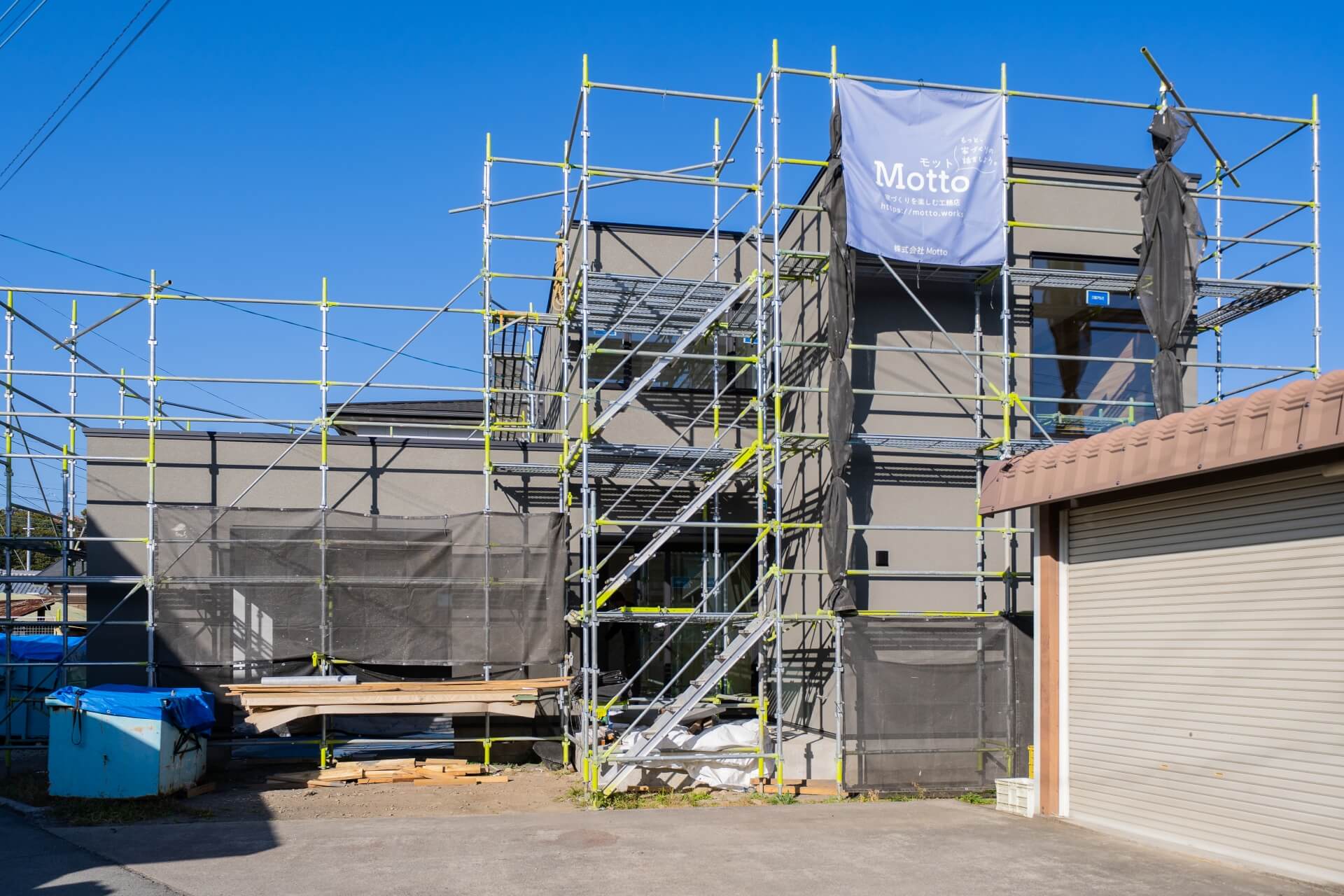 山梨県南アルプス市寺部の新築現場にて外観の様子。足場が組まれている。