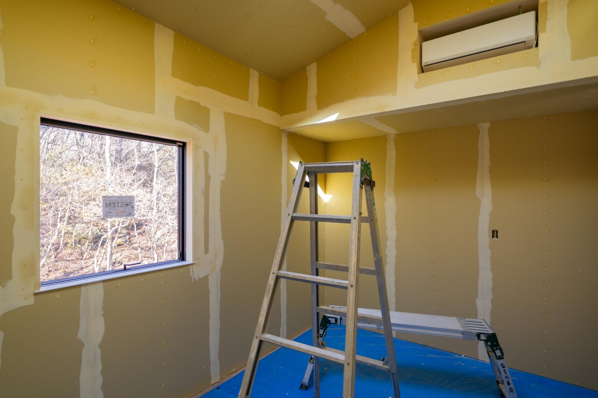 山梨県富士ケ嶺で建築中のヴィラの現場。パテ処理が終わった部屋の様子。