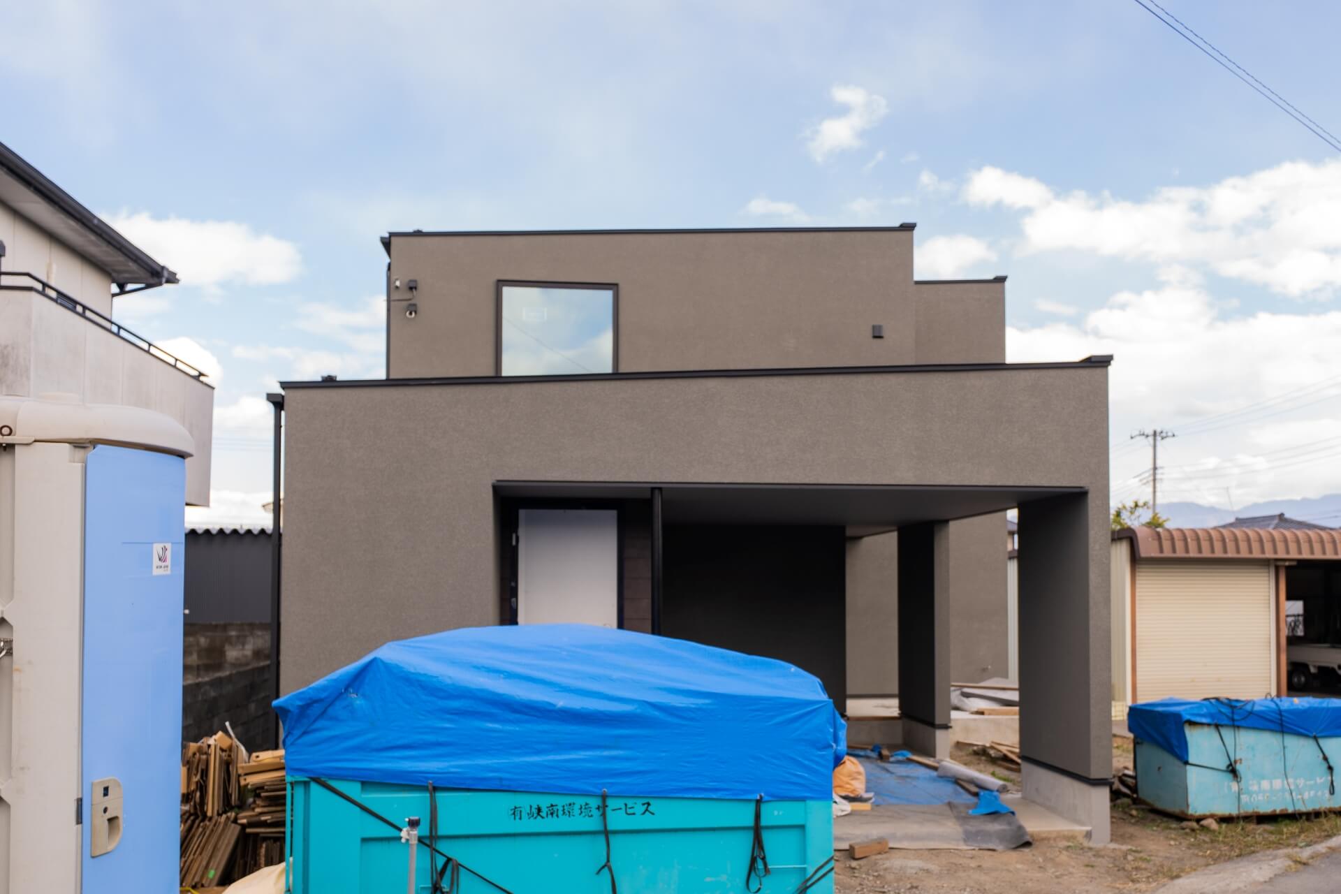 山梨県南アルプス市寺部の新築現場にてガレージ側の外観。