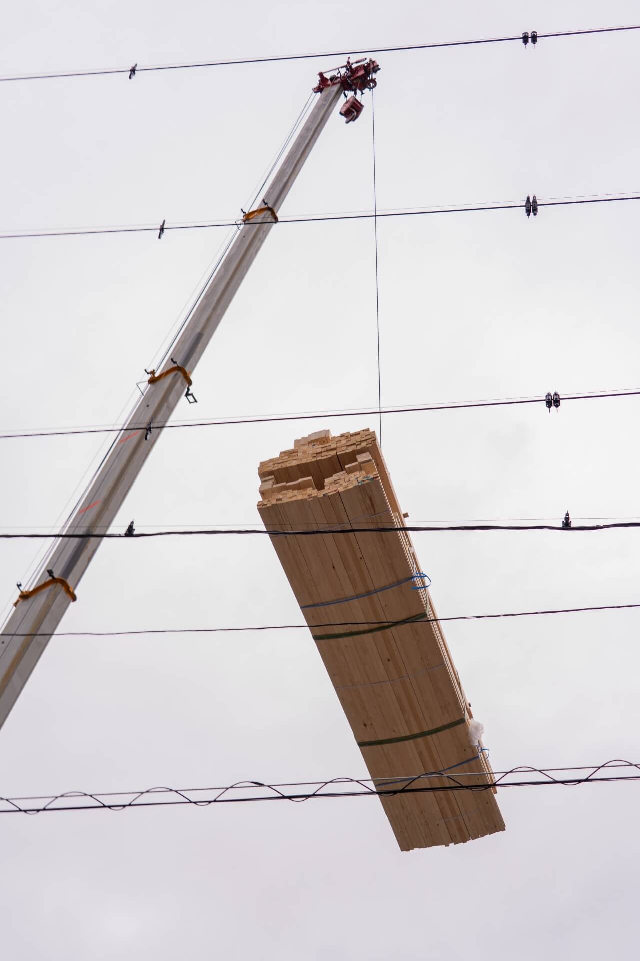 山梨県甲府市蓬沢の新築現場にてクレーンで吊り上げられた木造住宅の構造材。