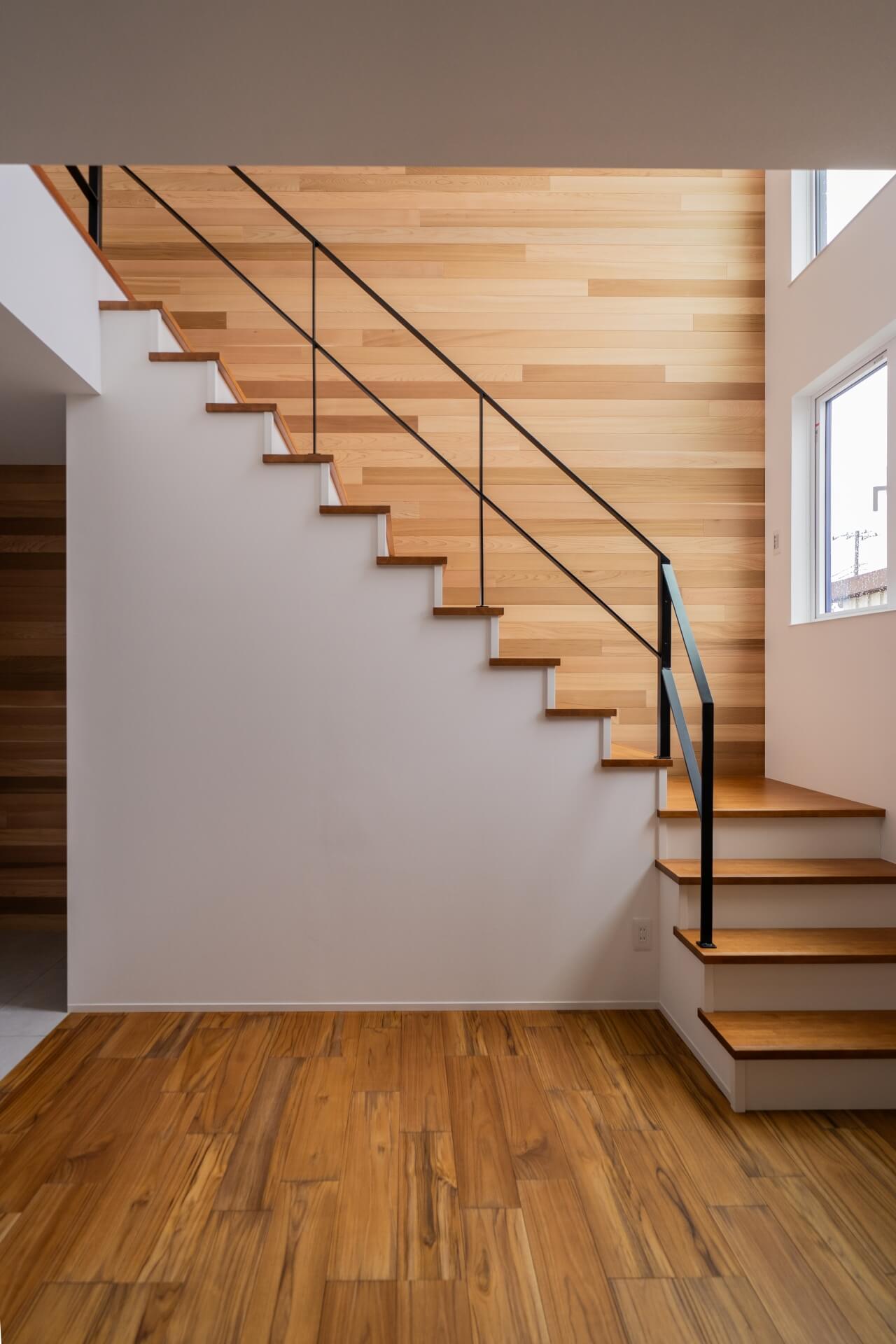 山梨県南アルプス市寺部の新築現場にて施工された階段。鉄骨のてすりと壁に張られたレッドシダー。