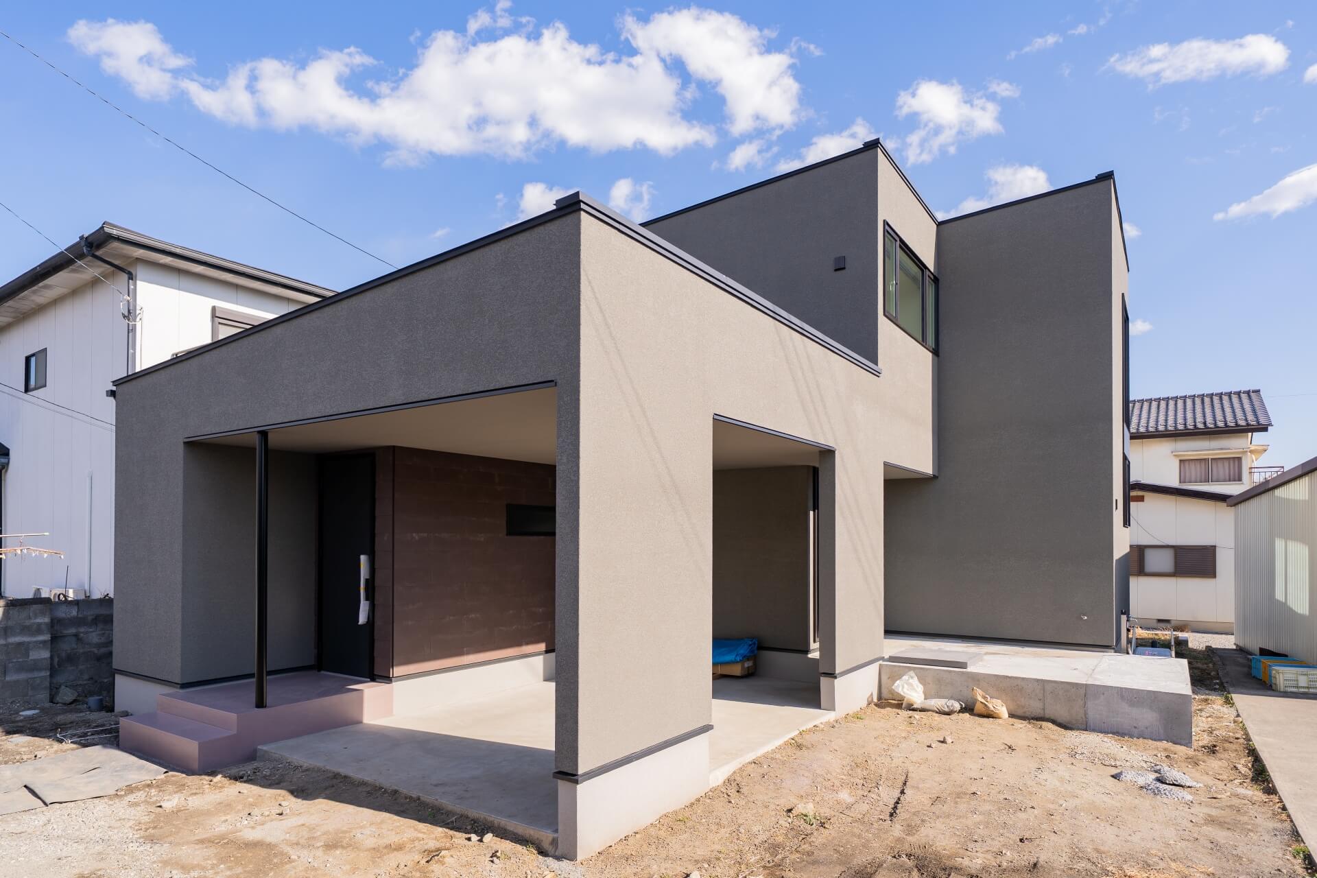 山梨県南アルプス市寺部の新築現場にてグレーの外観の建物。
