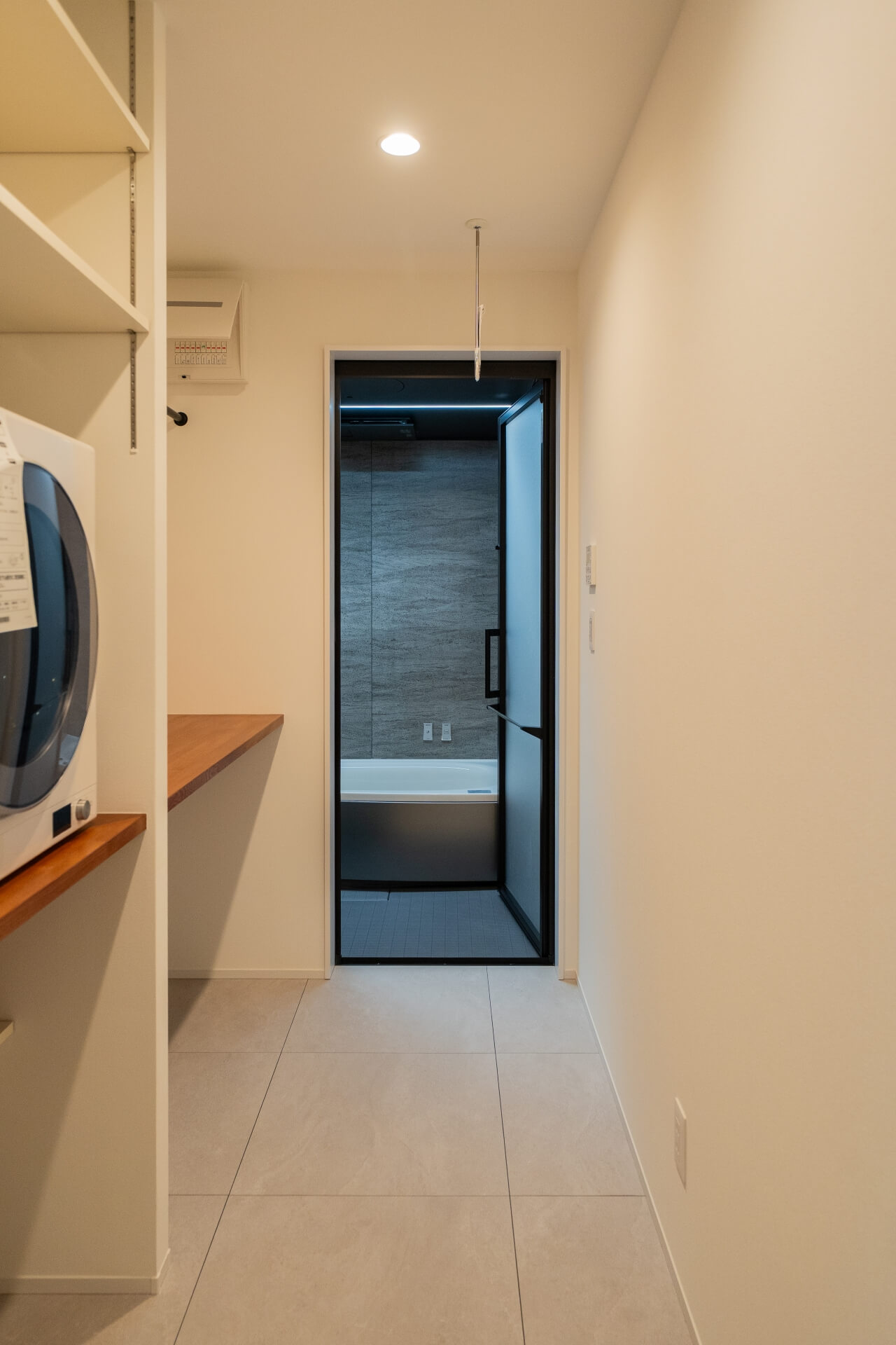 山梨県南アルプス市寺部の新築現場、ランドリースペースから浴室へと一直線につながる動線。洗濯機や作業カウンターを備え、家事効率を高めた設計。