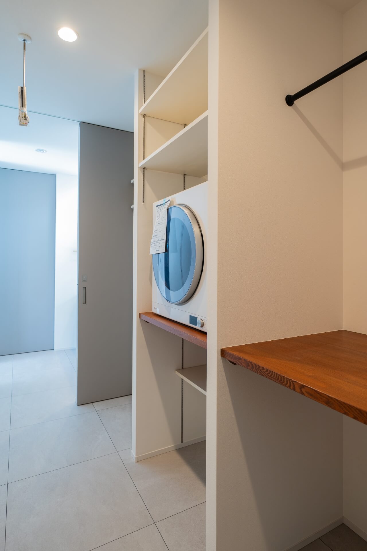 山梨県南アルプス市寺部の新築現場、乾燥機と可動棚を組み合わせたランドリースペース。家事効率を考えた収納計画。