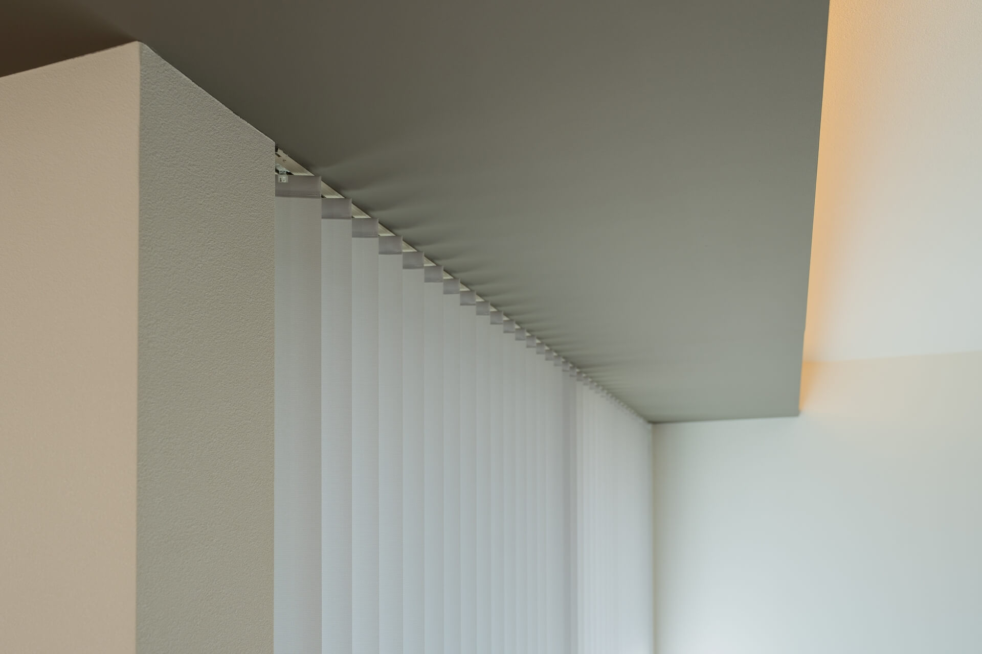 山梨県南アルプス市寺部の新築現場、バーチカルブラインドにより柔らかく拡散された自然光。均一な光が空間を包む。