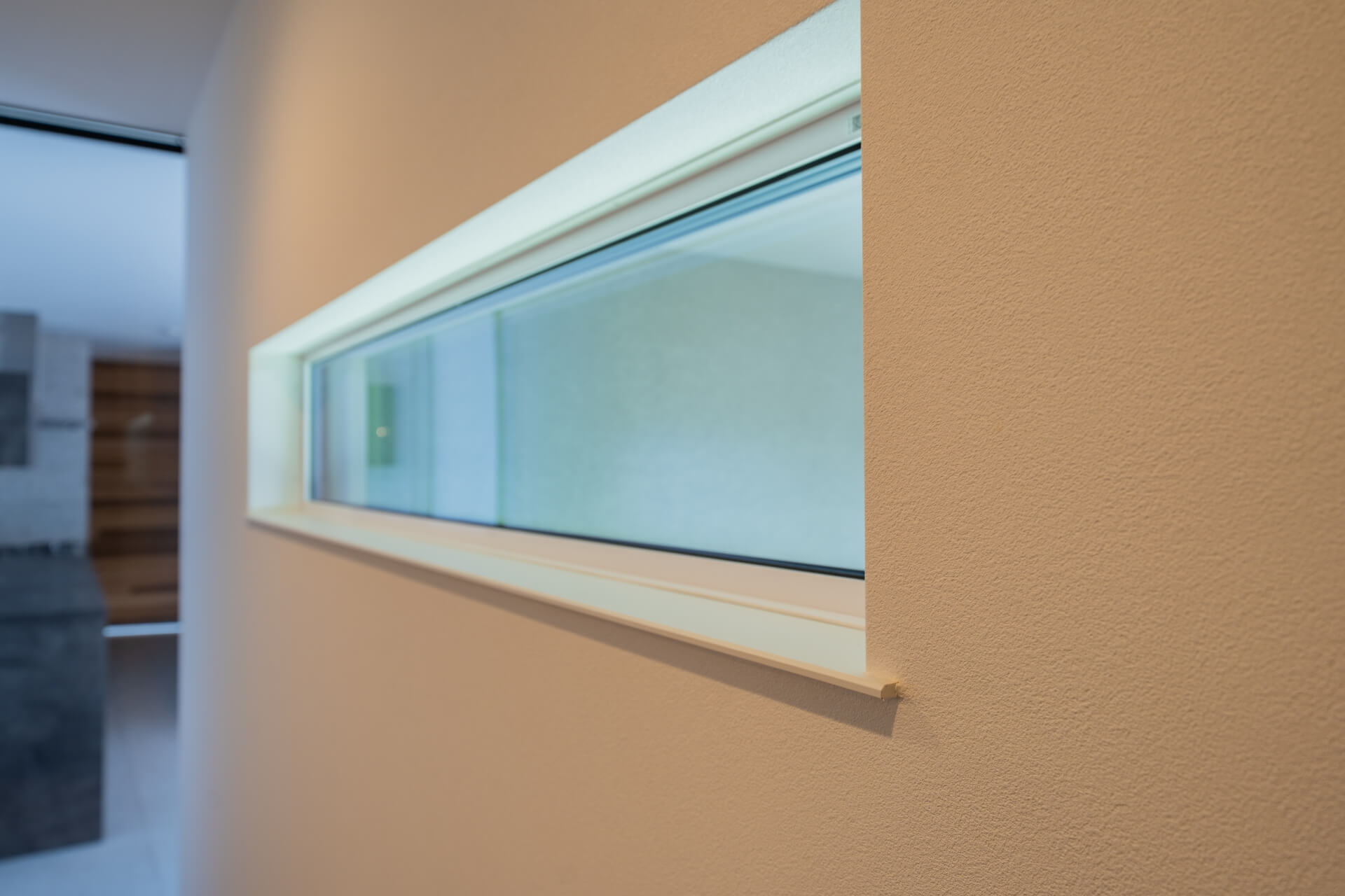 山梨県南アルプス市寺部の新築現場、壁に設けられた横長のスリット窓。外光を柔らかく取り込むディテール。