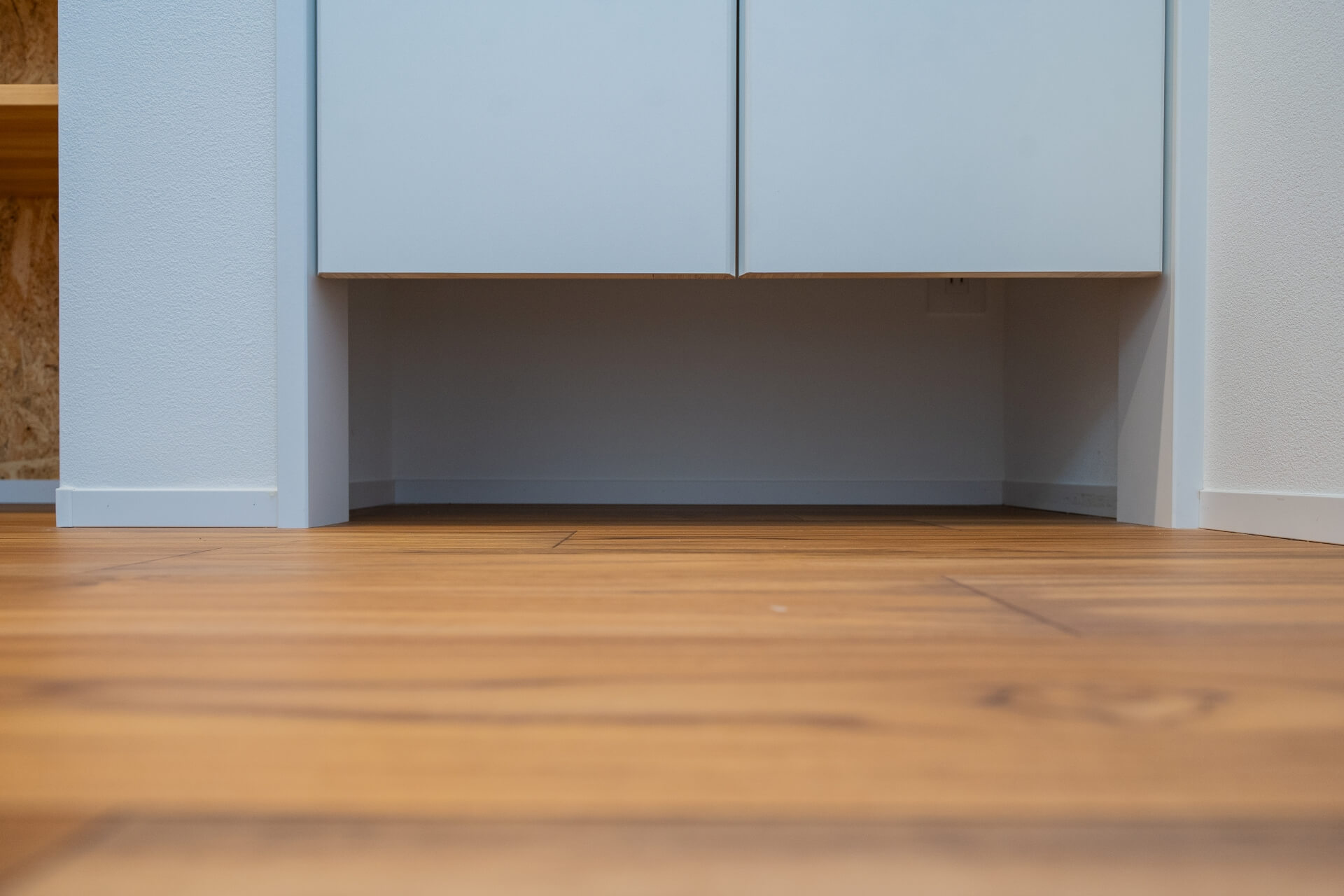 山梨県南アルプス市寺部の新築現場、木のフローリングと浮かせた収納下の空間（ルンバ基地）。