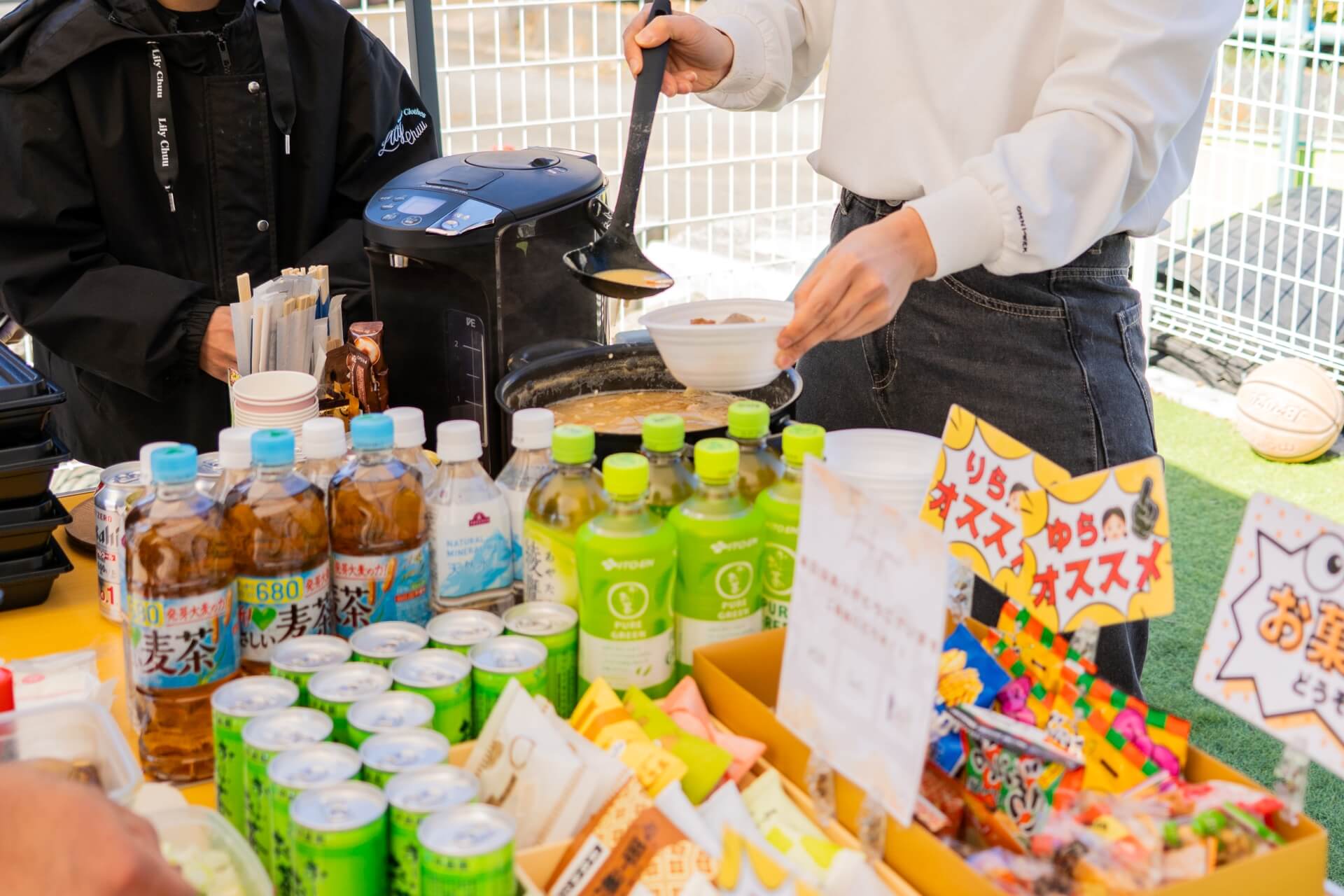 山梨県富士吉田市大明見の上棟現場で食事をよそう様子と飲み物が並ぶテーブル。