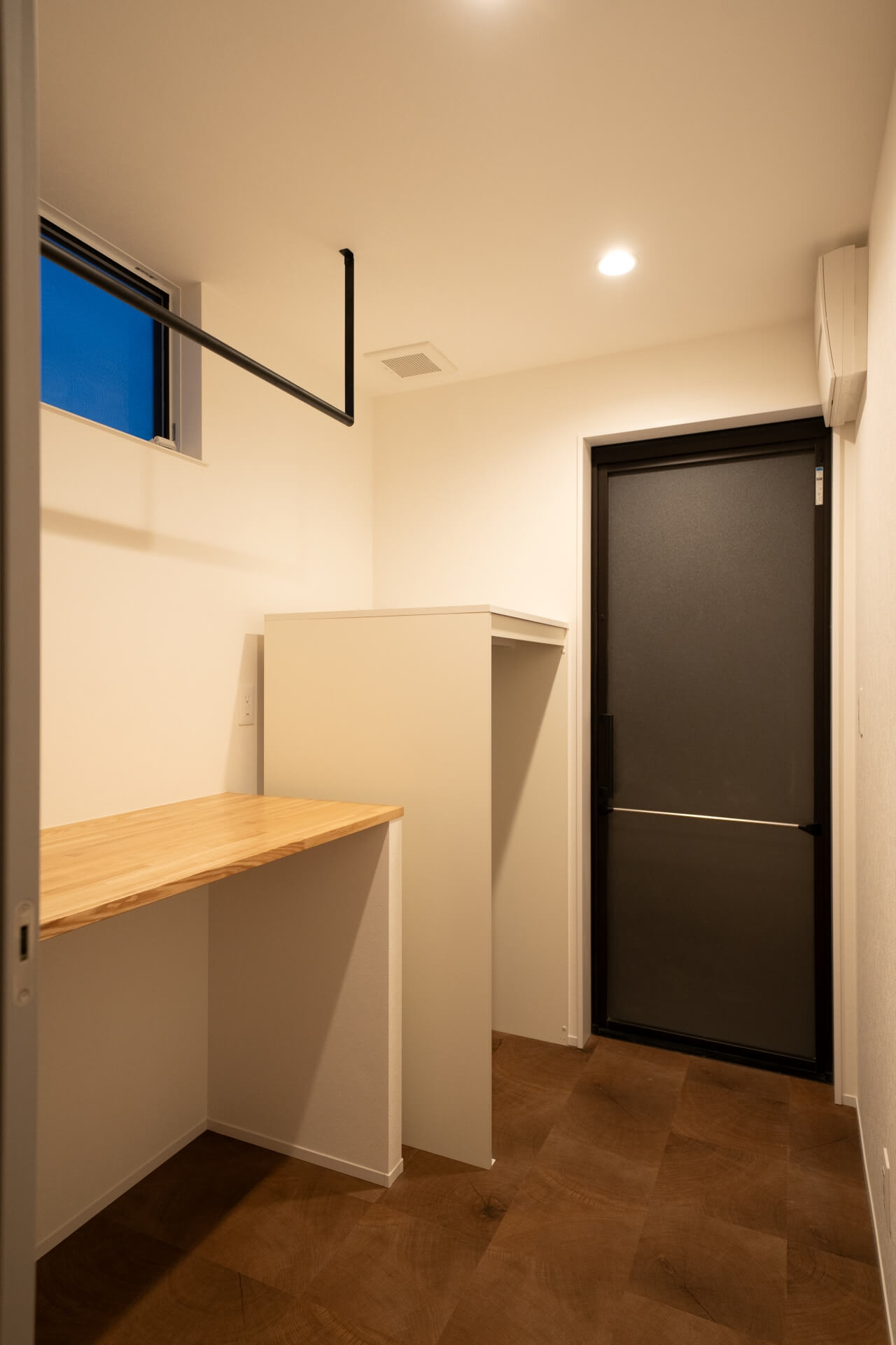 山梨県南アルプス市藤田の現場にて室内干し用のハンガーパイプと作業カウンターがあるランドリースペース。