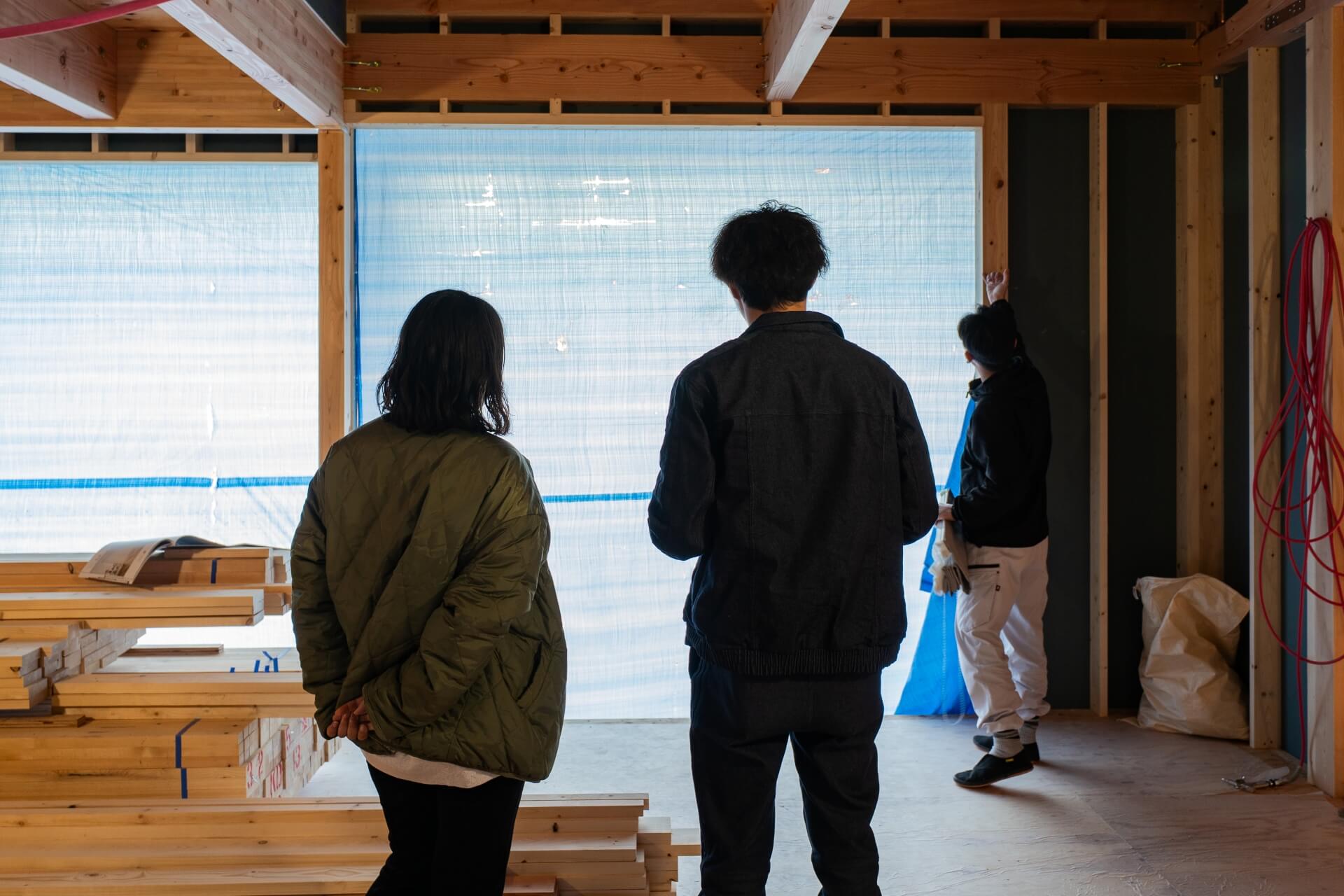 山梨県富士吉田市大明見の新築現場。建築途中の建物内部でサンプルをみながらカーテンの打ち合わせしている様子。