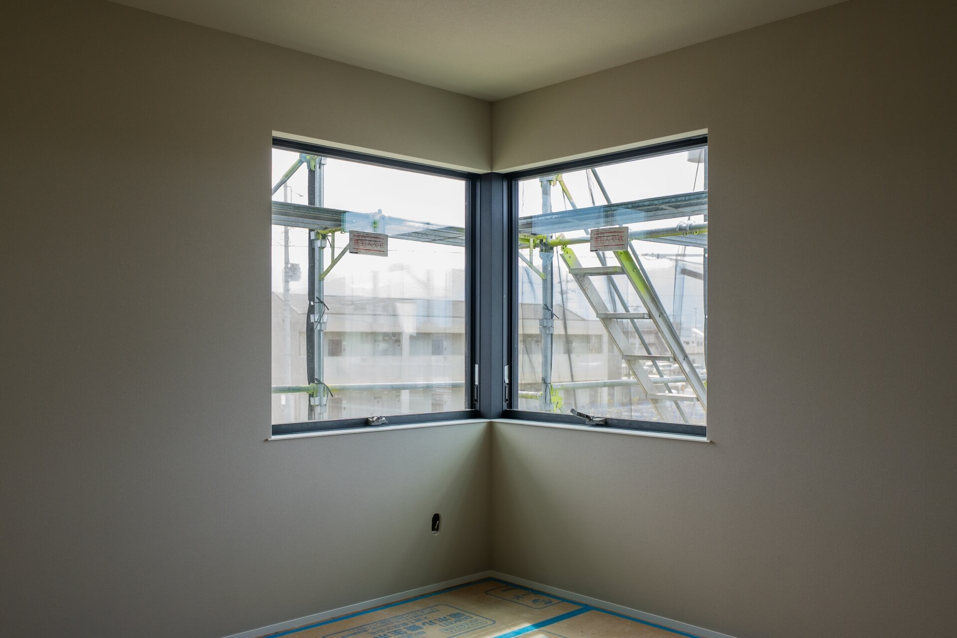 山梨県甲府市蓬沢の新築現場にてコーナー窓から光が差し込む洋室。