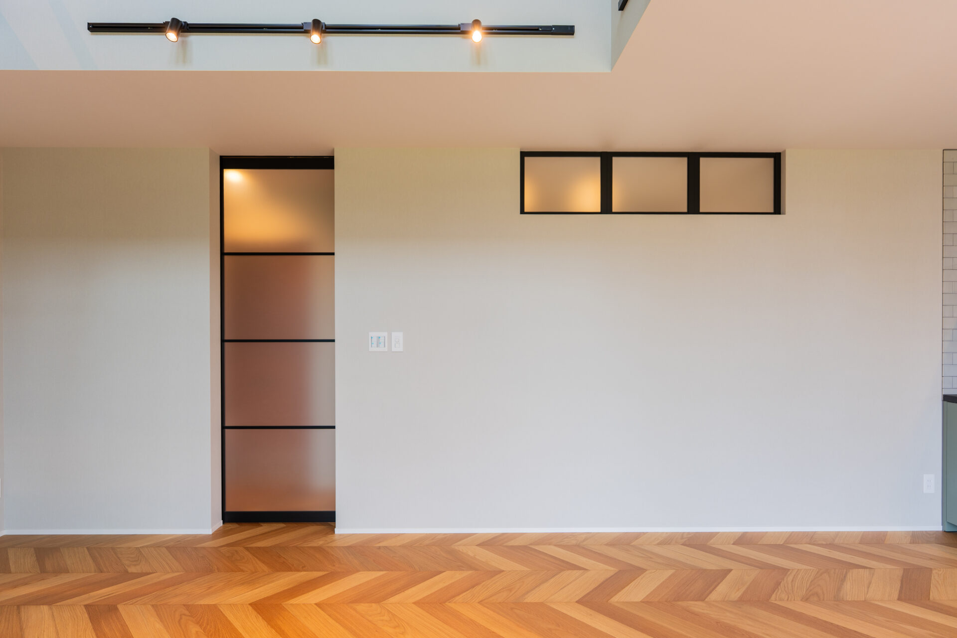 北杜市大泉町西井出の建築現場。室内窓とガラス建具を取り入れたヘリンボーン床のLDK。