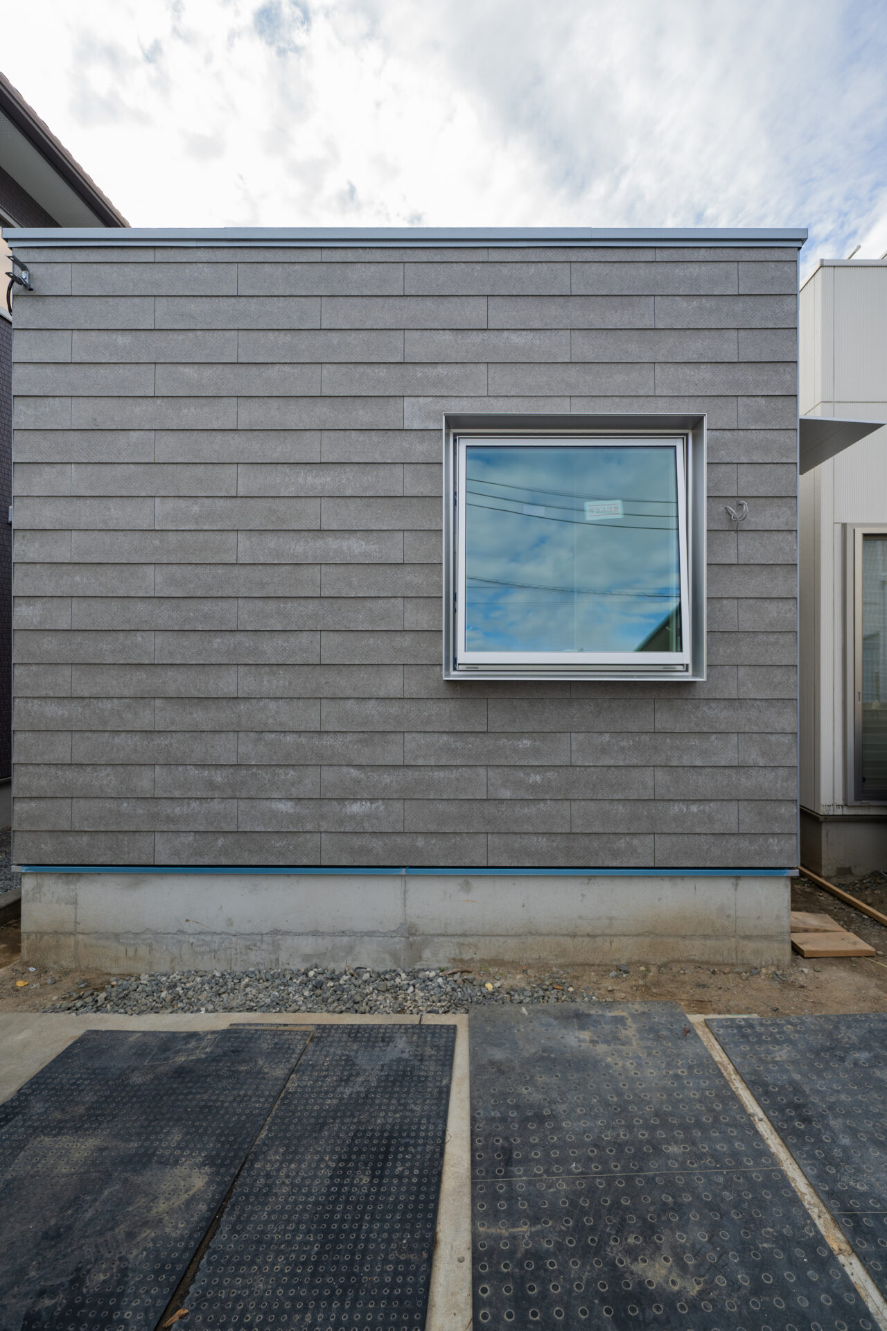 甲府市蓬沢町の美容室新築工事。足場が外れ、外壁や窓まわりが見えるようになった美容室の外観。